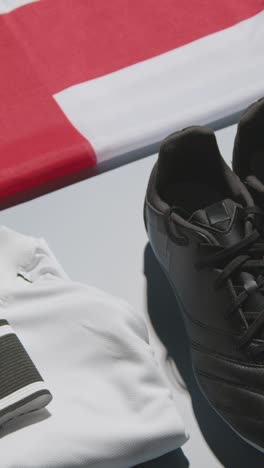 Still-Life-Studio-Video-Vertical-Shot-De-Botas-De-Fútbol-Bandera-Inglesa-Camiseta-Y-Pantalones-Cortos-Y-Brazalete-De-Capitanes